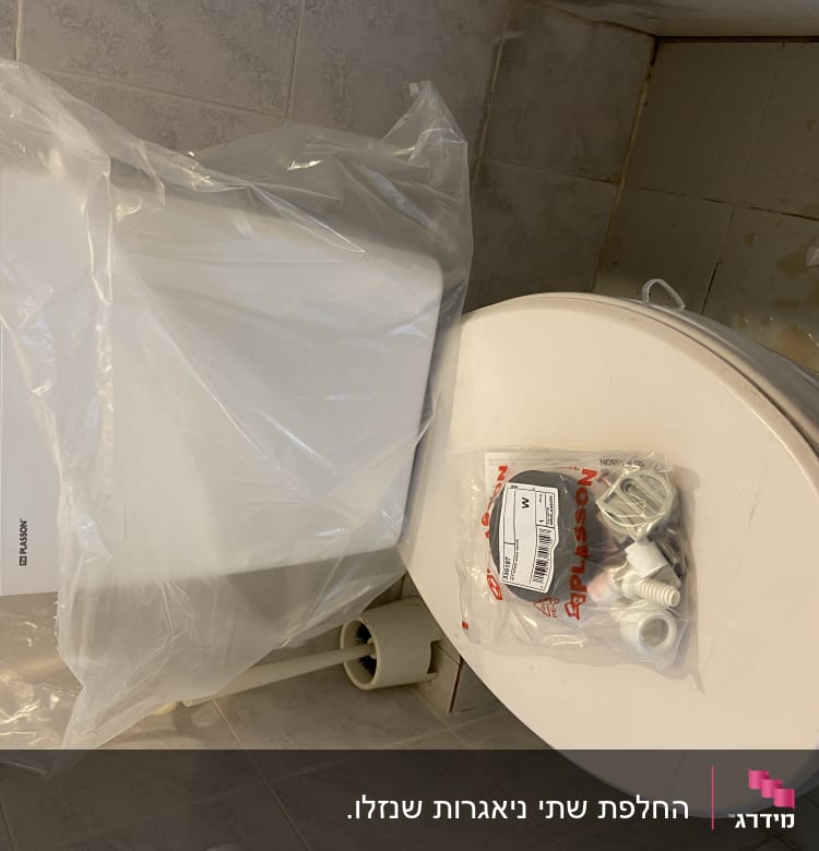 אסלה עם חלקי אינסטלציה על המכסה